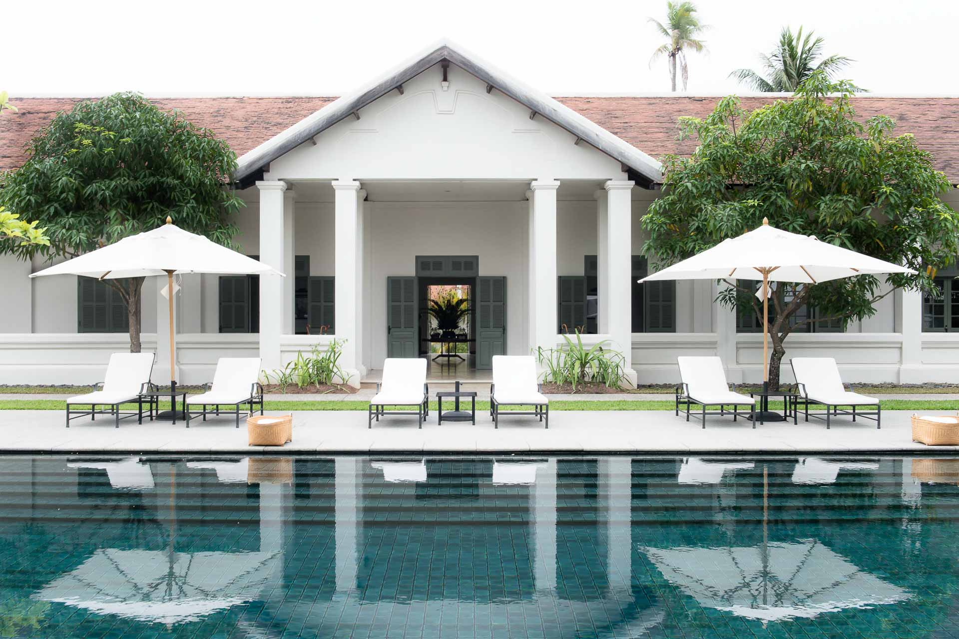 Minimalist white courtyard and emerald pool at Amantaka Luang Prabang